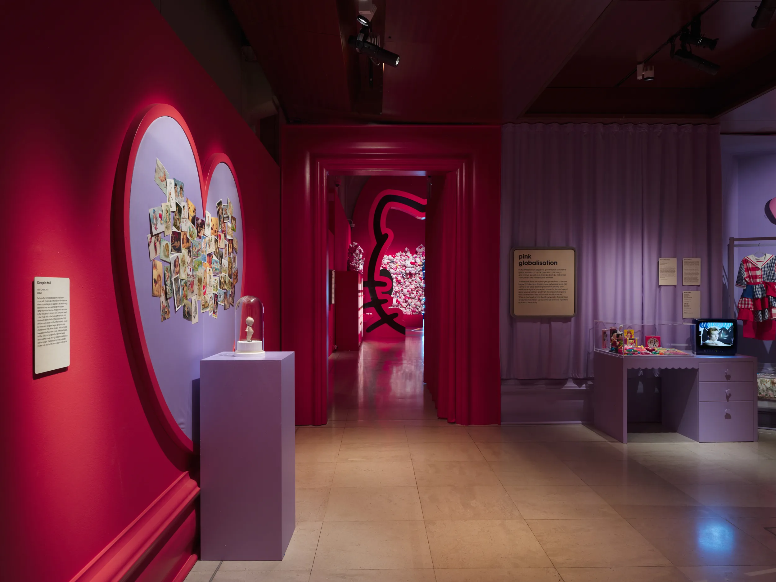 Red wall with purple heart and collage of images, doorway shows half neon Hello Kitty face.