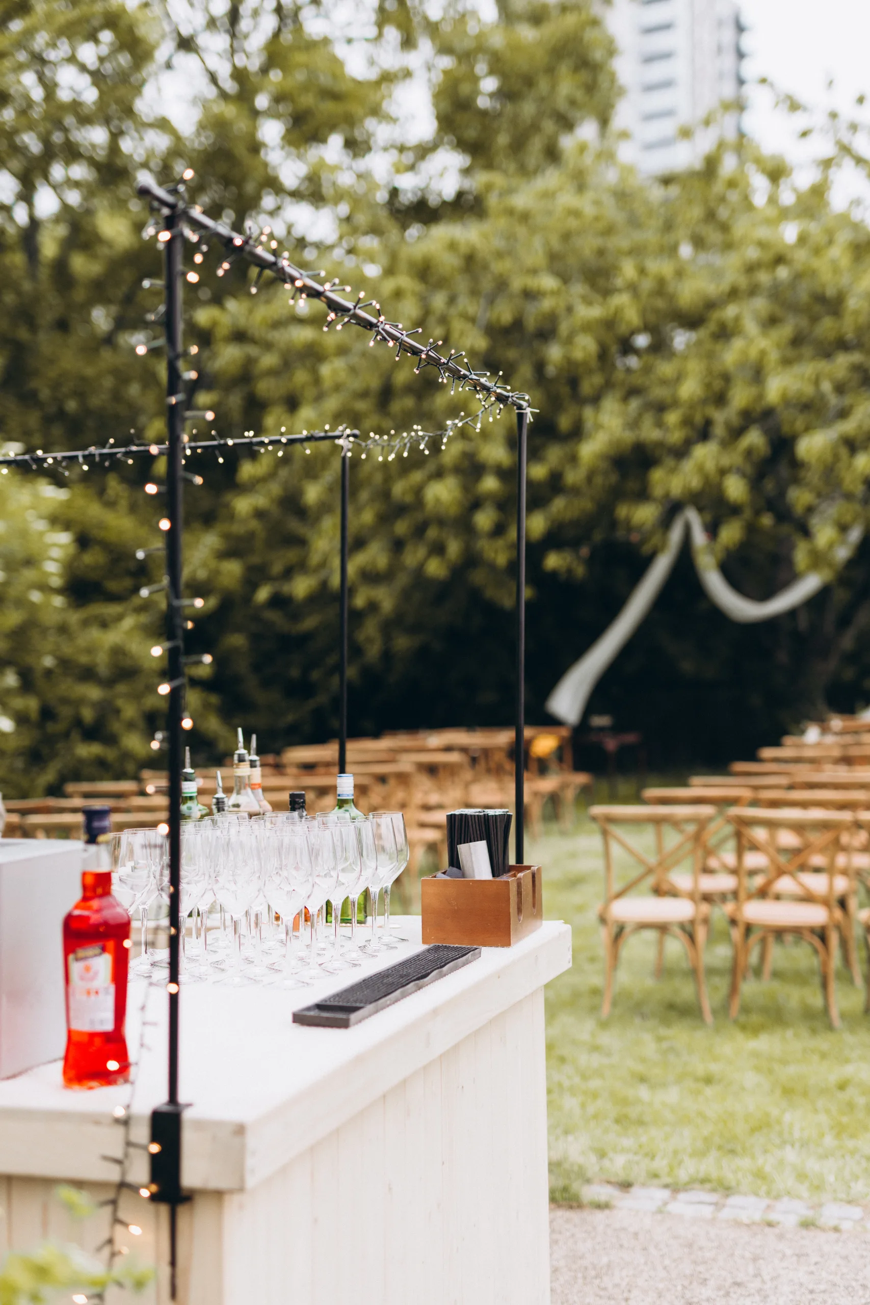 Outdoor bar and seating area for wedding ceremony surrounded by trees