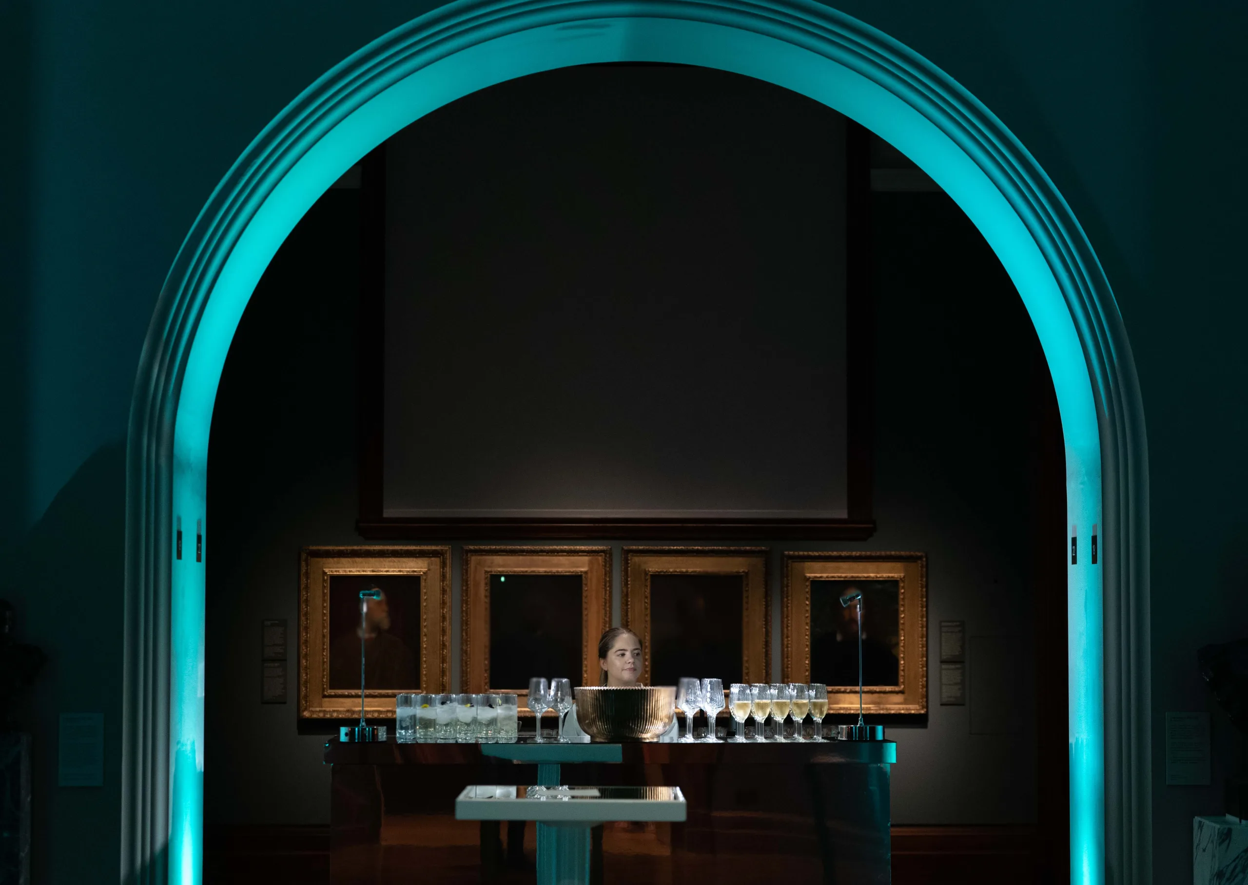 Cool blue lit archway above table of drinks in The National Portrait Gallery