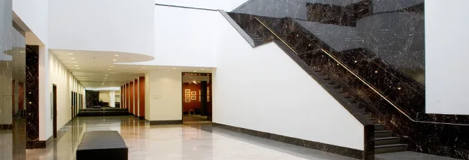 National Gallery Anneberg Court Lower Hall C view of white hallway and dark brown marble pattern stone staircase