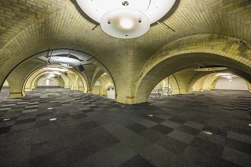 Vault space at Old Billingsgate with arches between spaces with large overhead white lights