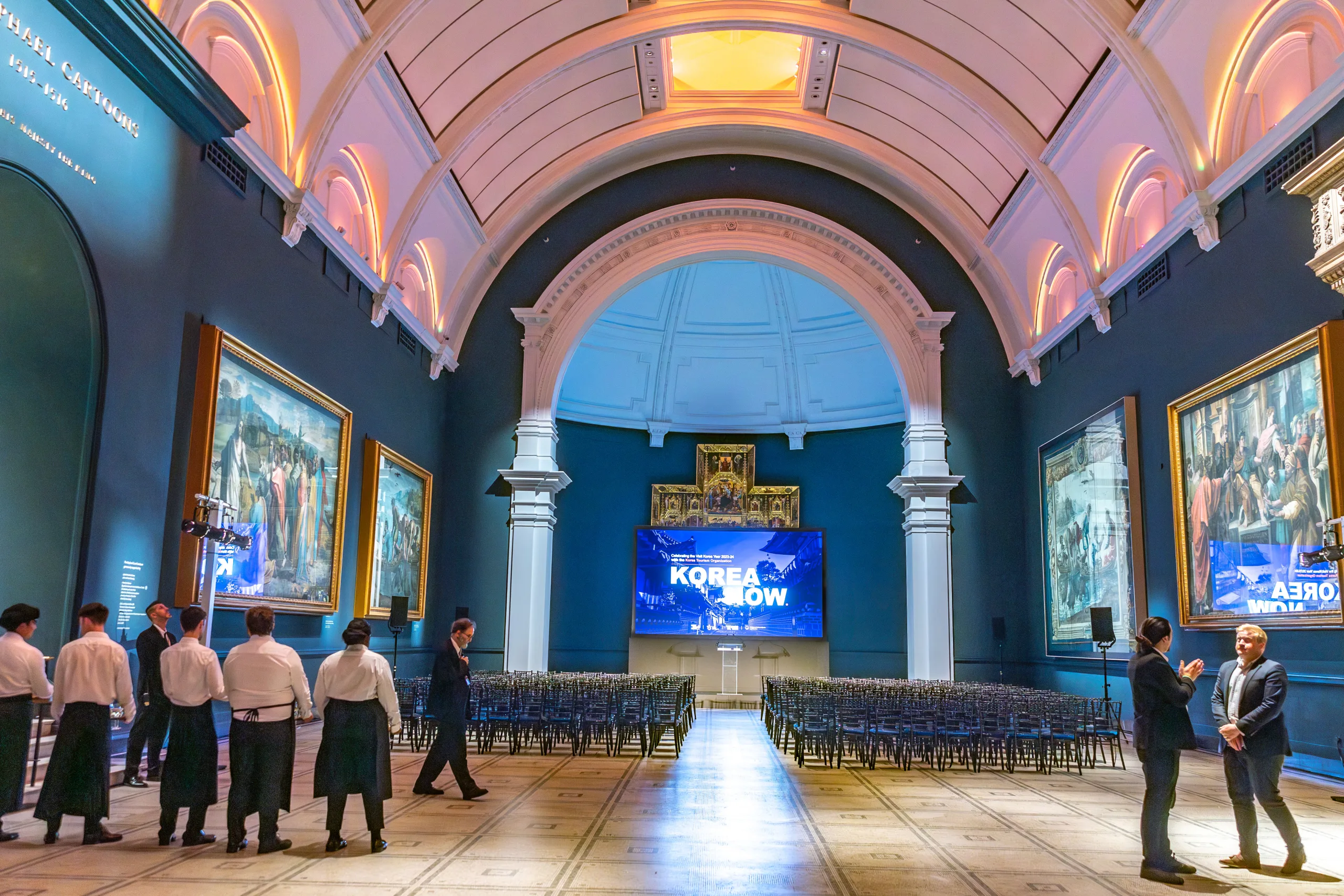 Korea event at V&A, the high-ceiling room with sea-blue walls and bright arched ceiling, set up with seating in front of a large screen